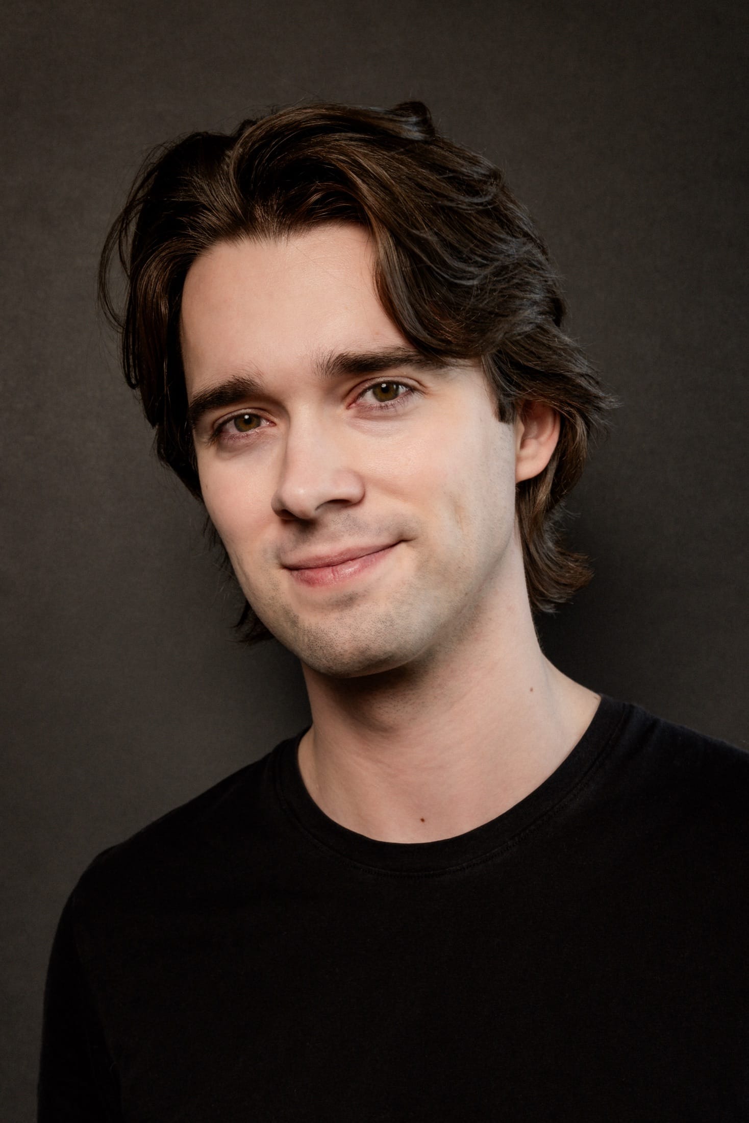 Headshot, half smile, black t-shirt